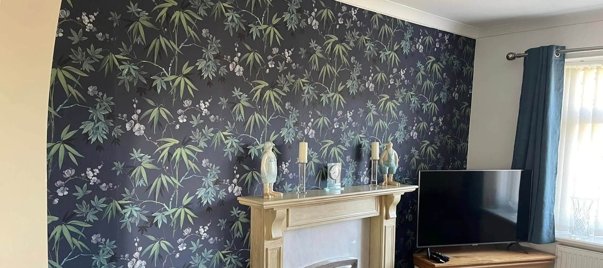 Interior feature wall wallpaper installation in a Mumbles (Swansea) home with green plant and flower design, installed by Daffodil Decor.