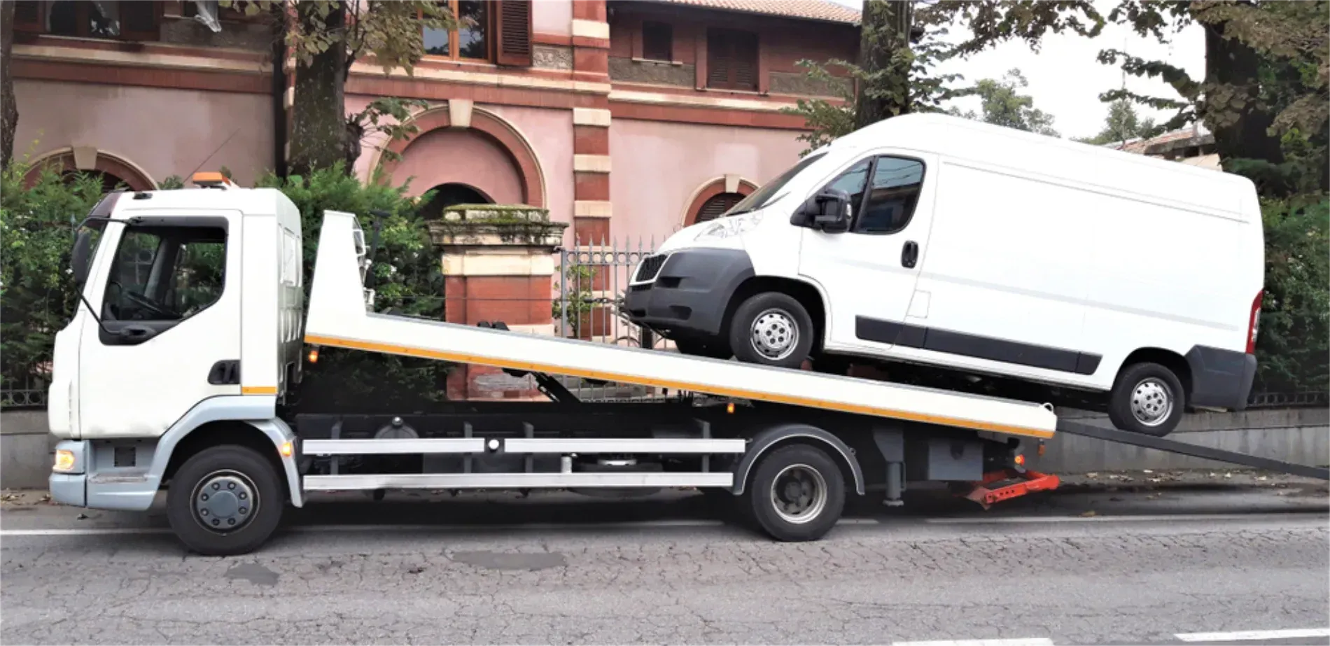A White Van Being Loaded Onto a Tow Truck on an Asphalt Road — JP's Towing and Transport in Gatton, QLD