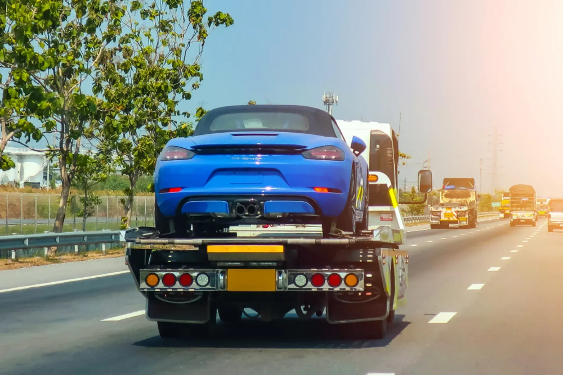 A Bright Blue Sports Car Being Transported on a Flatbed Tow Truck — JP's Towing and Transport in Kingsthorpe, QLD