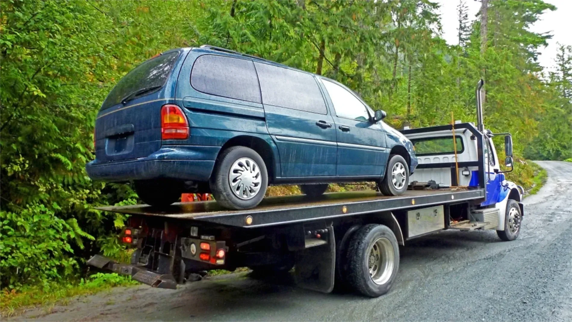 A Person in a Red Shirt Works to Attach a White Truck — JP's Towing and Transport in Gatton, QLD