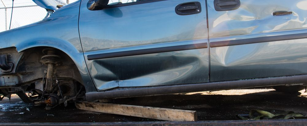 A Teal Car With Body Damage — JP's Towing and Transport in Oakey, QLD
