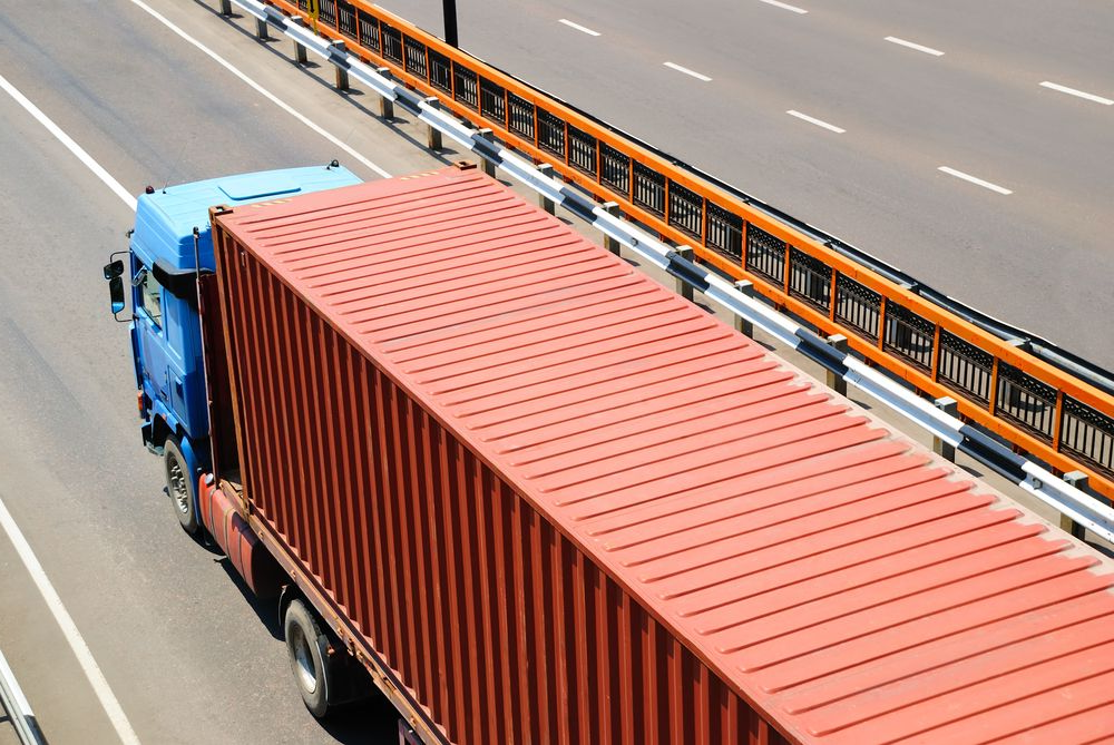 A Blue Semi-truck With a Long, Corrugated Red Cargo Container — JP's Towing and Transport in Westbrook, QLD