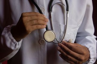 Doctor holding a stethoscope against a white coat