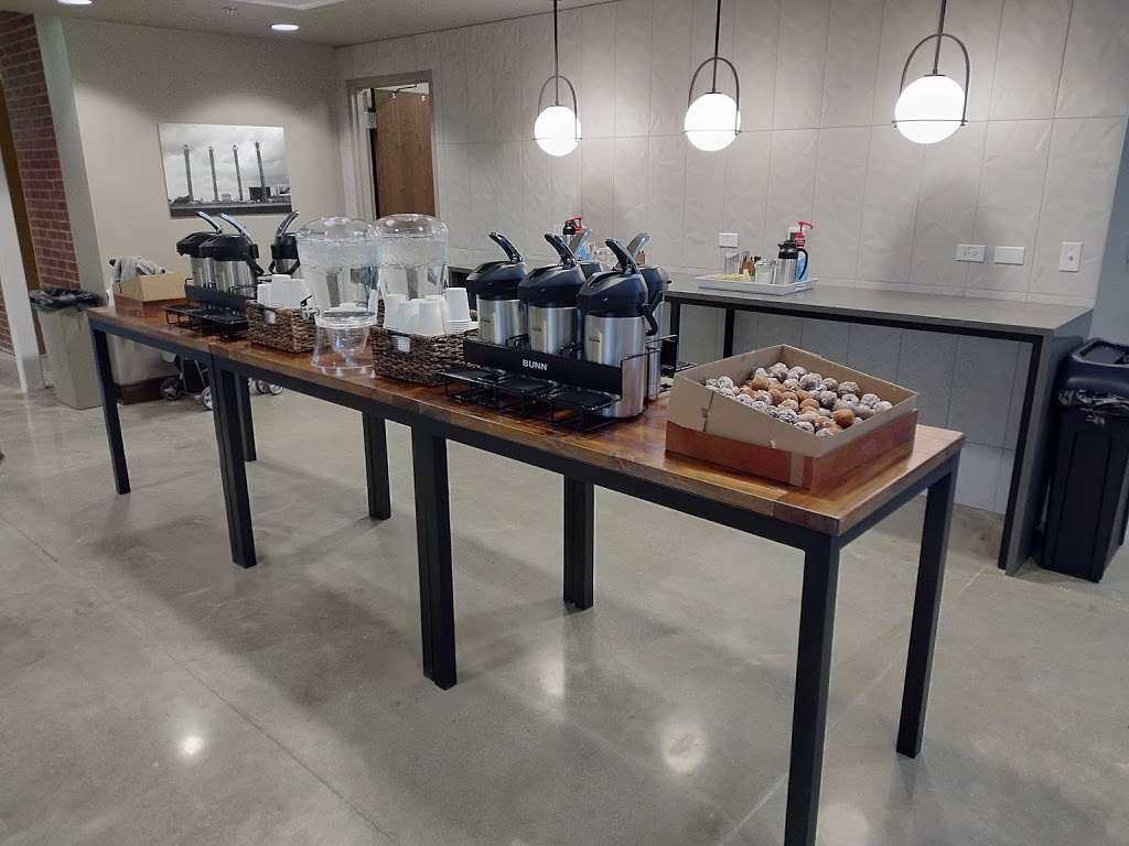 A long table with a variety of coffee makers on it.