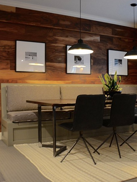 A dining room with a table and chairs and pictures on the wall
