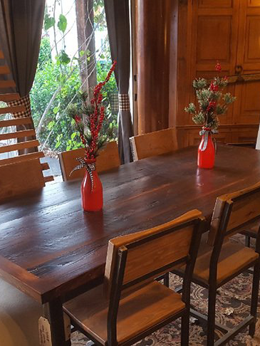 A dining room table with a vase of flowers on it.