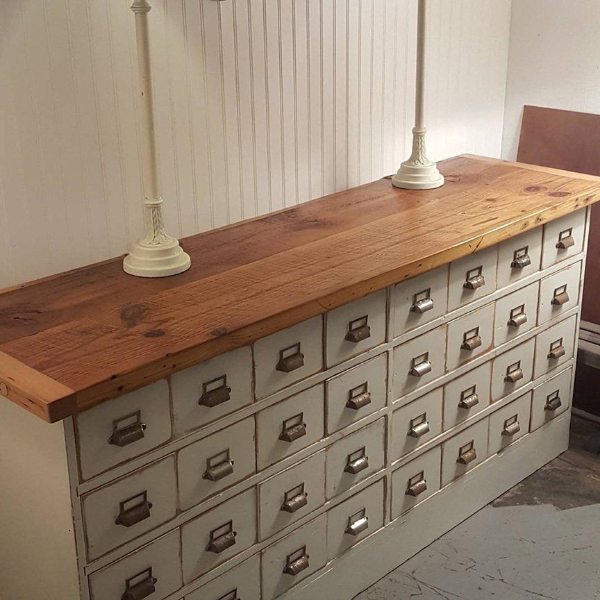 A dresser with many drawers and a wooden top