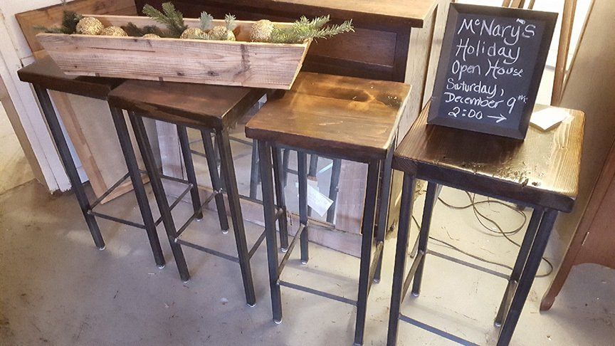 Three wooden bar stools are sitting next to each other in a room.