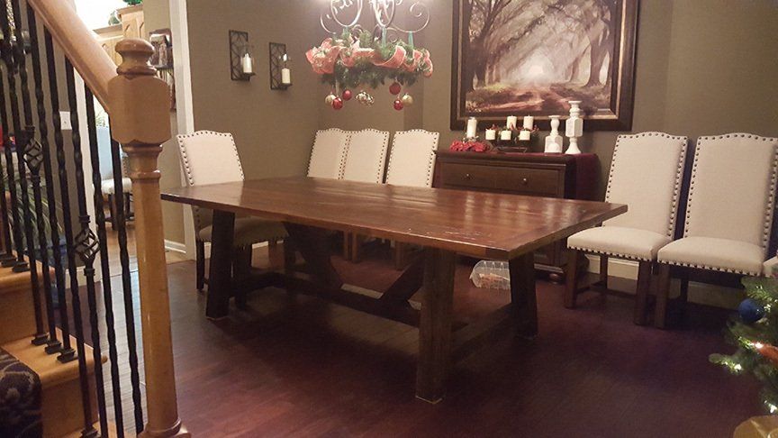 A dining room with a wooden table and white chairs