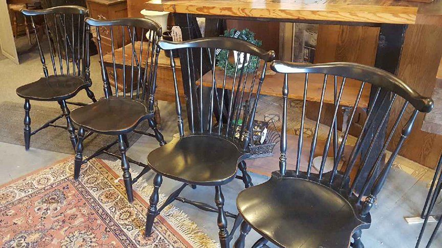 A group of wooden chairs are sitting next to each other on a rug.