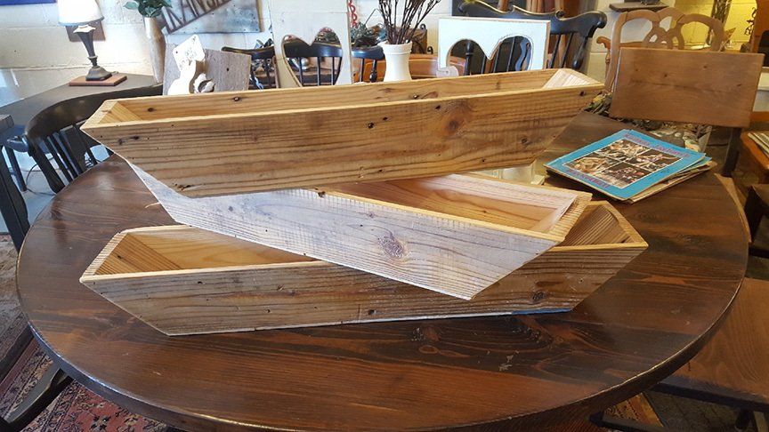Three wooden boxes are stacked on top of each other on a wooden table.
