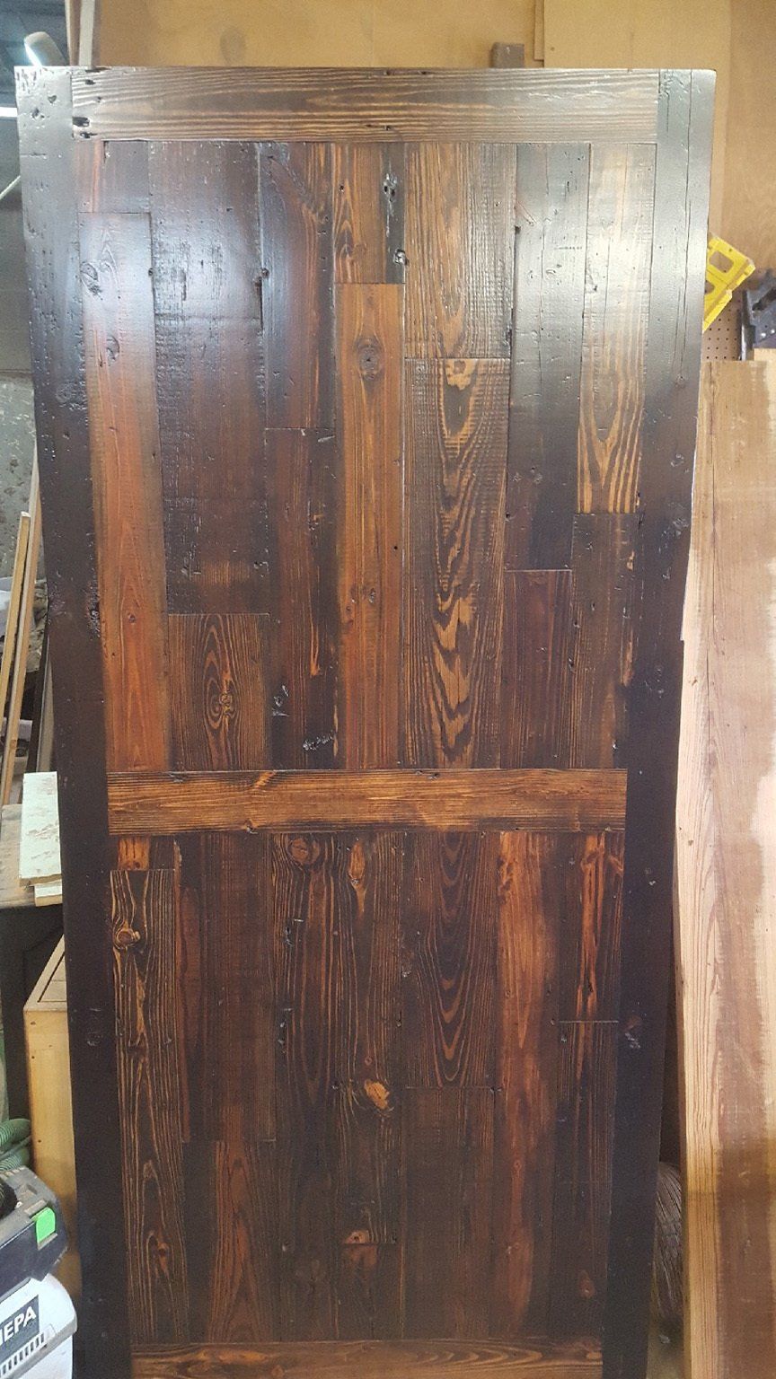 A wooden door is sitting on top of a wooden table in a room.