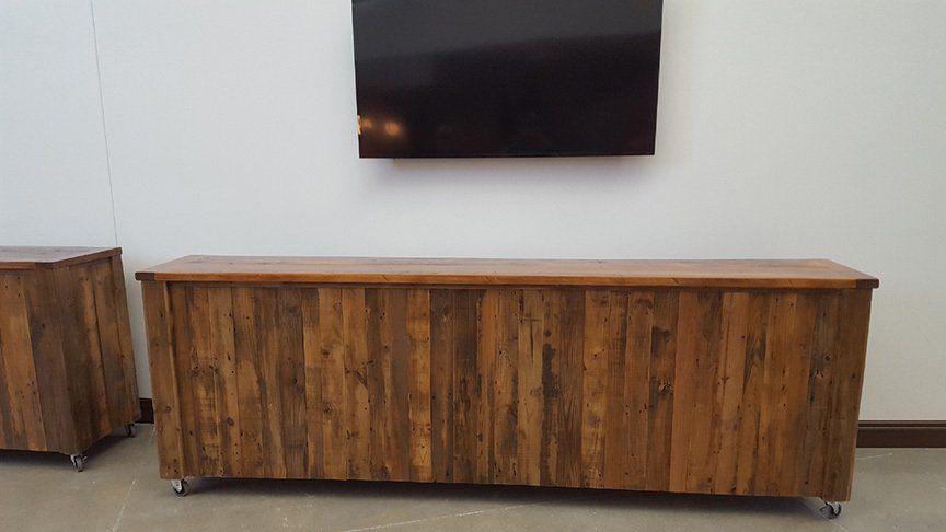 A wooden entertainment center with a flat screen tv mounted to the wall.