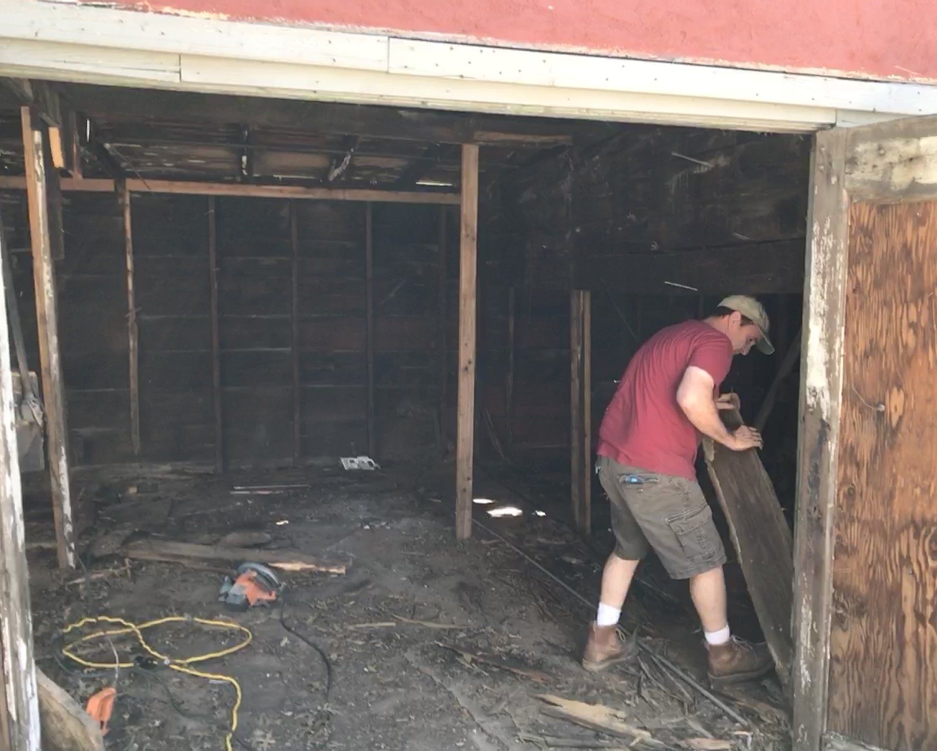 A man in a red shirt is working in a garage