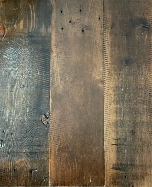 A close up of a piece of wood with nails in it.