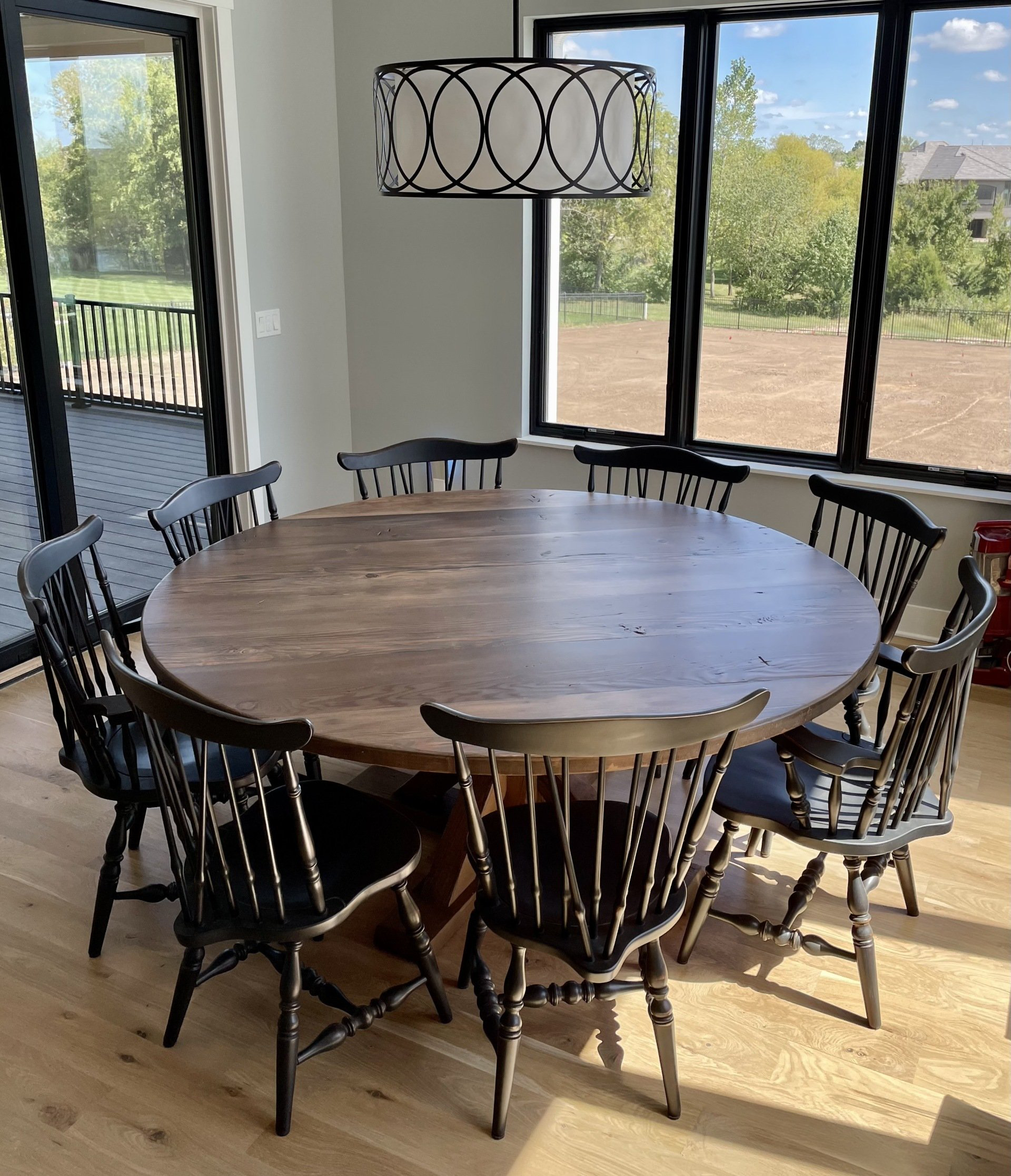 A dining room with a round wooden table and chairs.