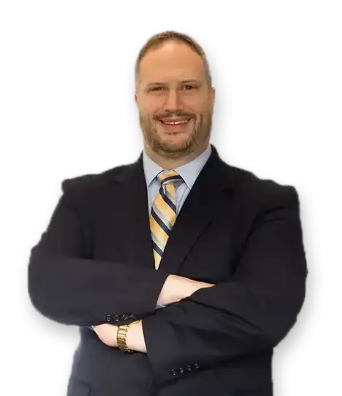 Man in navy blazer and white shirt smiles, head and shoulders portrait.