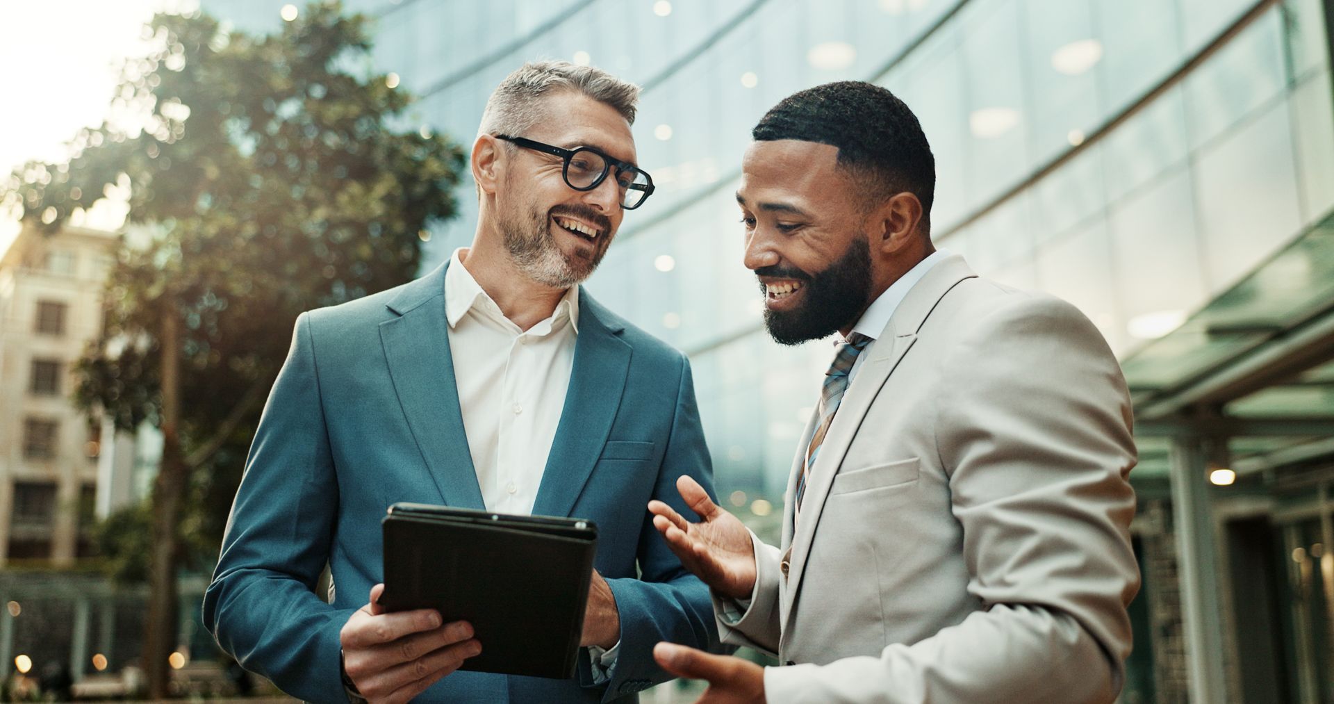 Aerial view of a car on a road, flanked by green fields.
