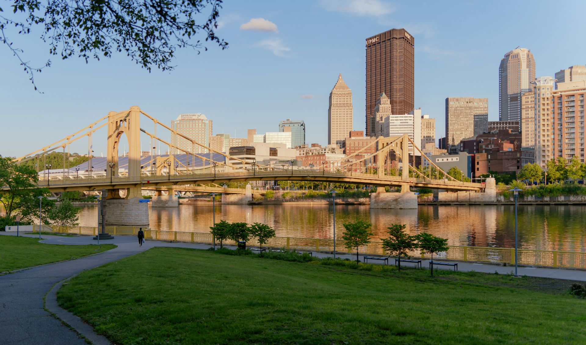 Aerial view of a car on a road, flanked by green fields.