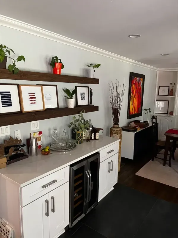 Home bar with floating shelves, art, wine fridge, and decorative items.