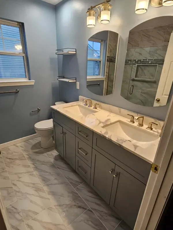 Bathroom with blue walls, gray vanity, marble countertop, and tiled floor.