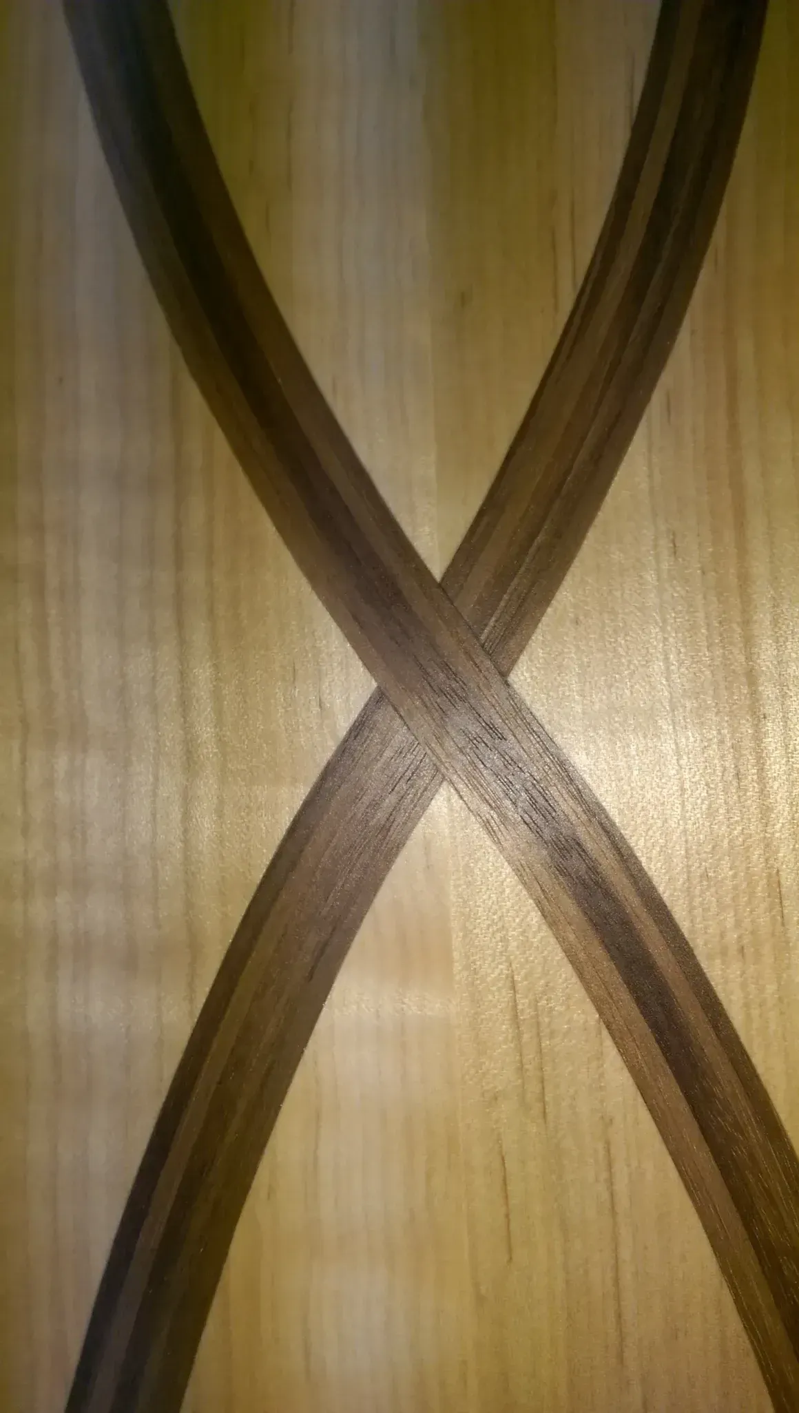 Wooden surface with a dark, intersecting X design.