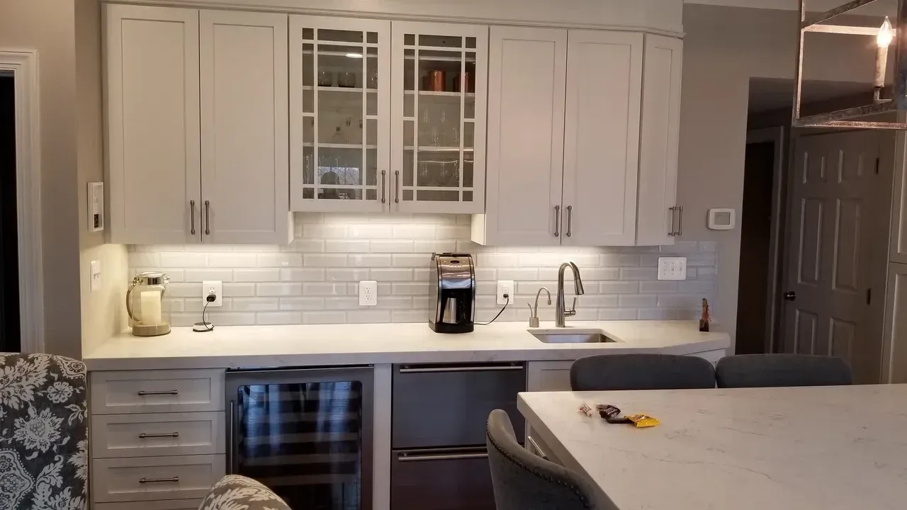 Modern kitchen with white cabinets, built-in appliances, and a counter with a sink.