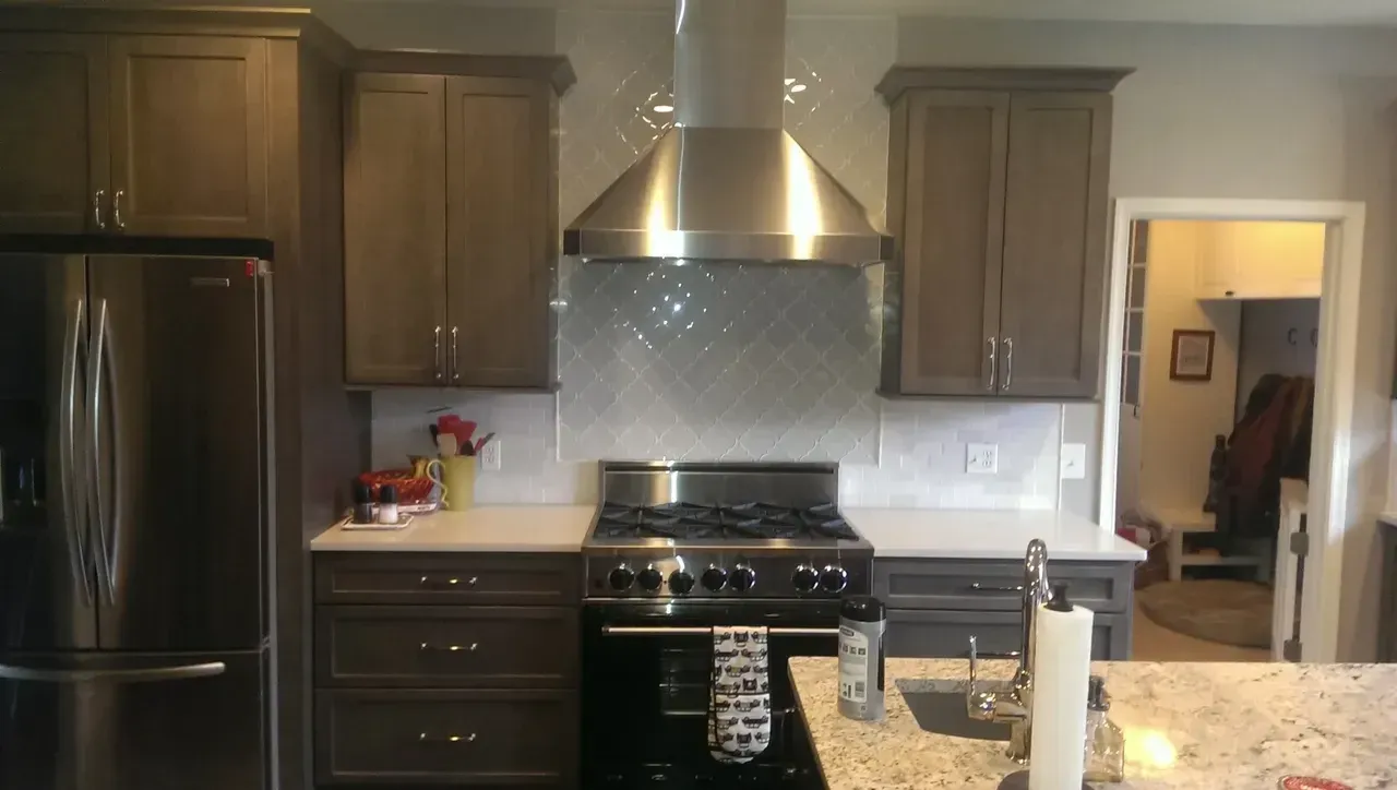 Kitchen with stainless steel appliances, grey cabinets, and white countertops.