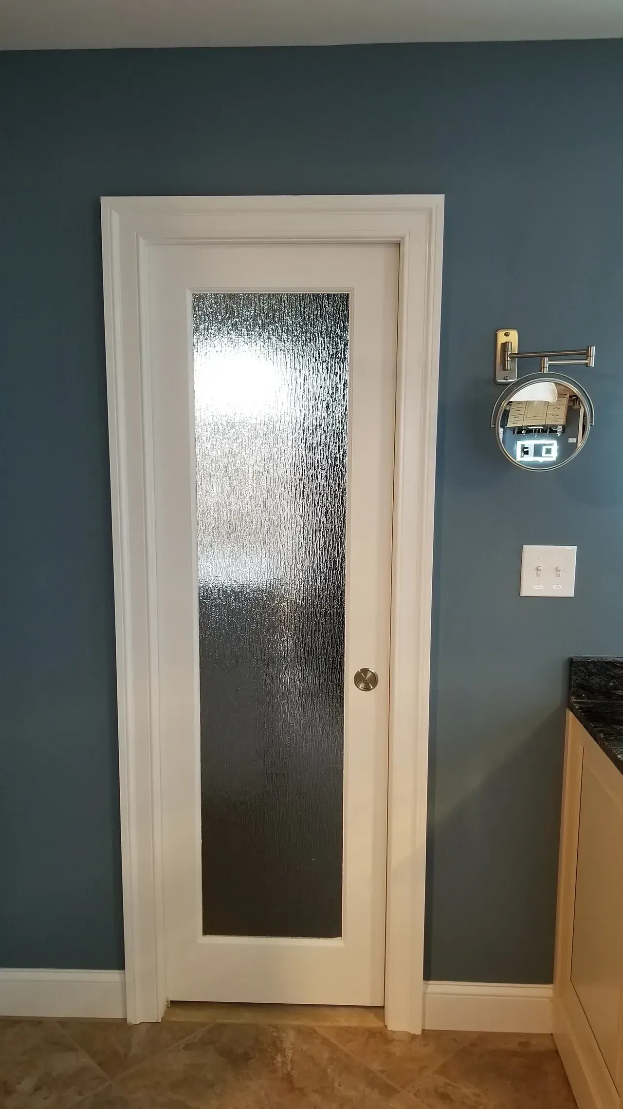 White-framed glass door on blue wall; a small robot on right wall.