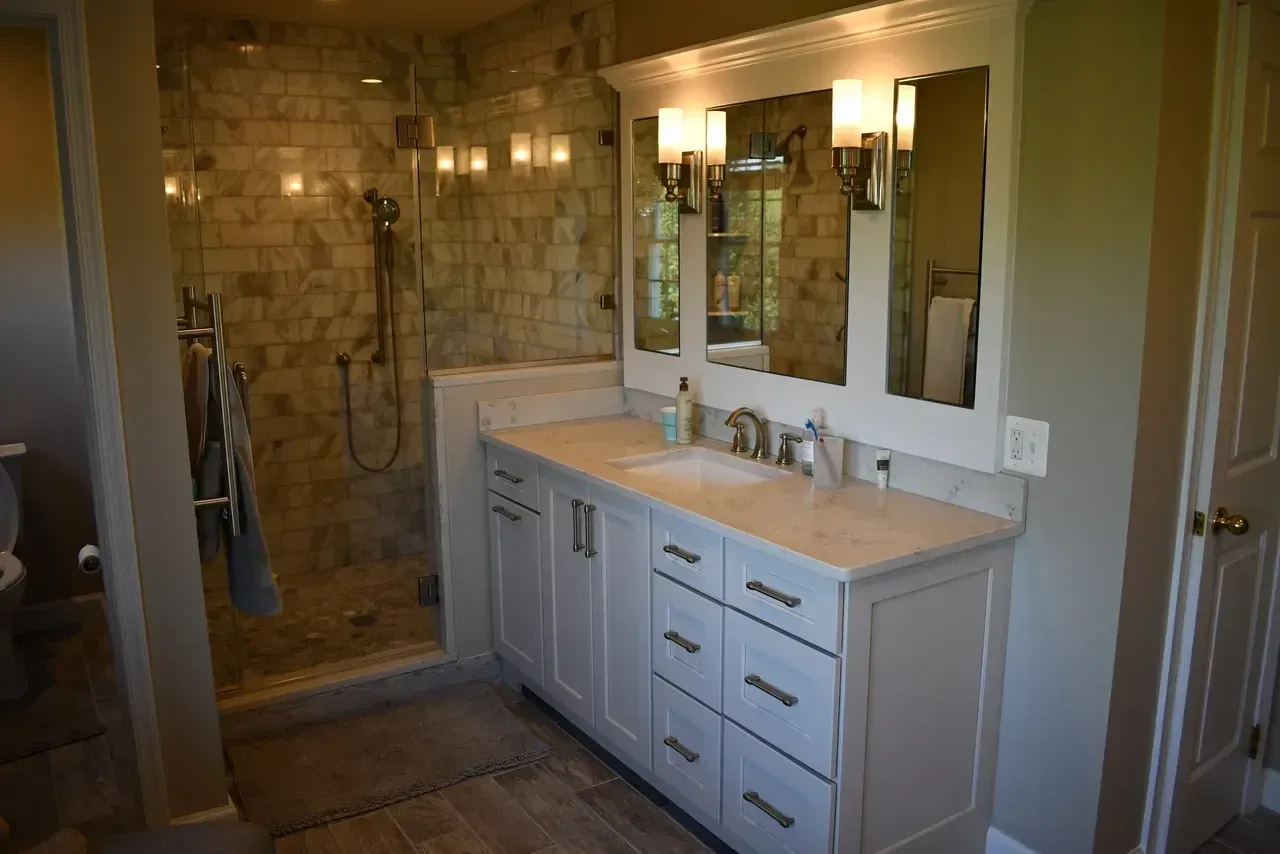 Bathroom with a white vanity, a glass shower, and beige walls.