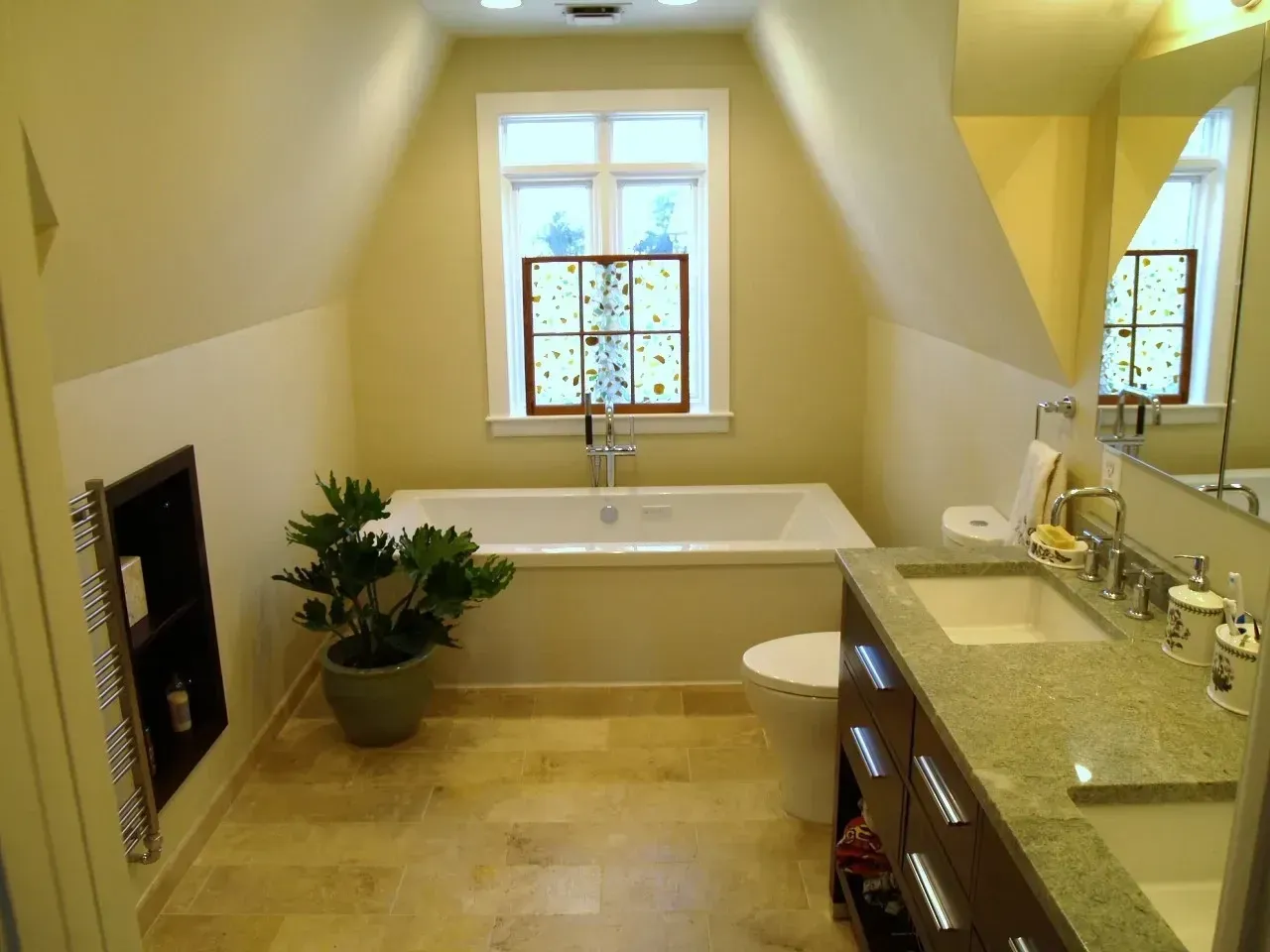 Bathroom with a white bathtub, toilet, and sink. Beige walls, window, and wood-look flooring.