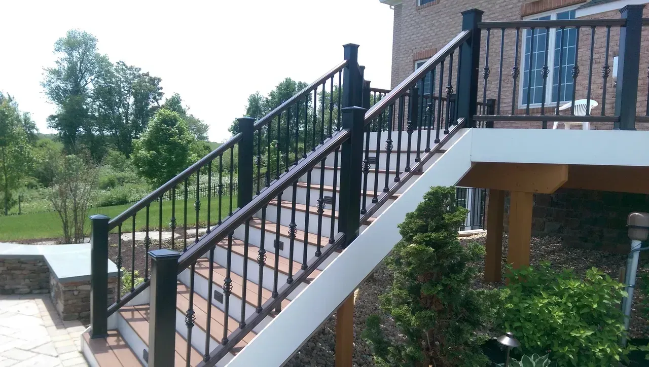 Black deck railing with decorative balusters on outdoor stairs.