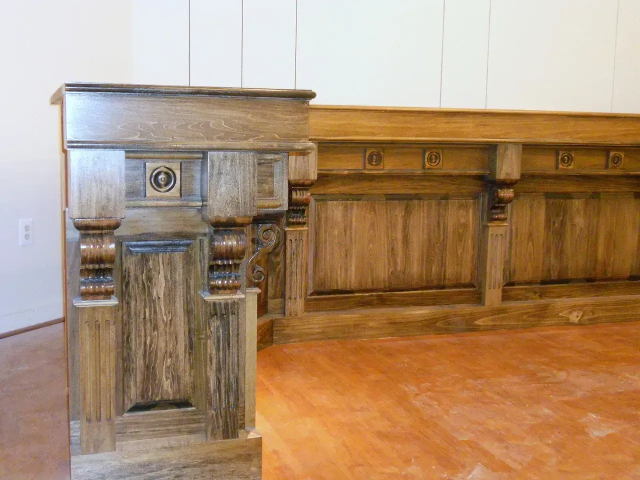 Wooden bar with decorative columns and paneling. Brown and tan colors.