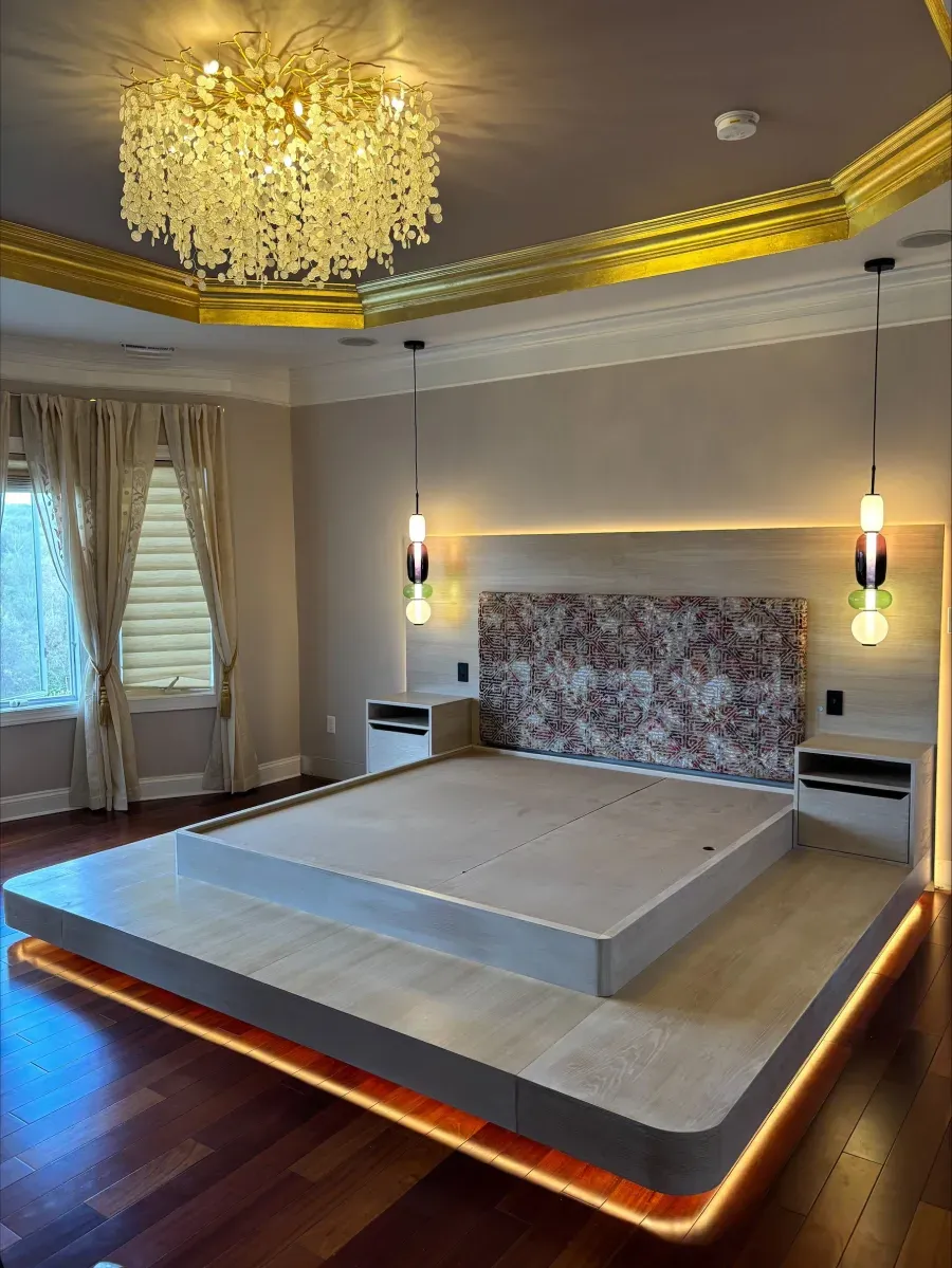 Luxurious bedroom with illuminated platform bed, marble headboard, and ornate chandelier.
