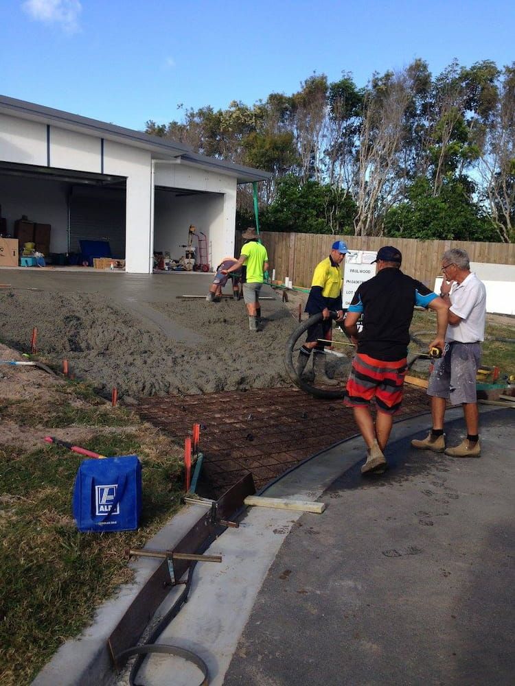 A Group of Men Are Working on a Concrete Driveway — Tweed Coast Concrete Pumping in Chinderah, NSW