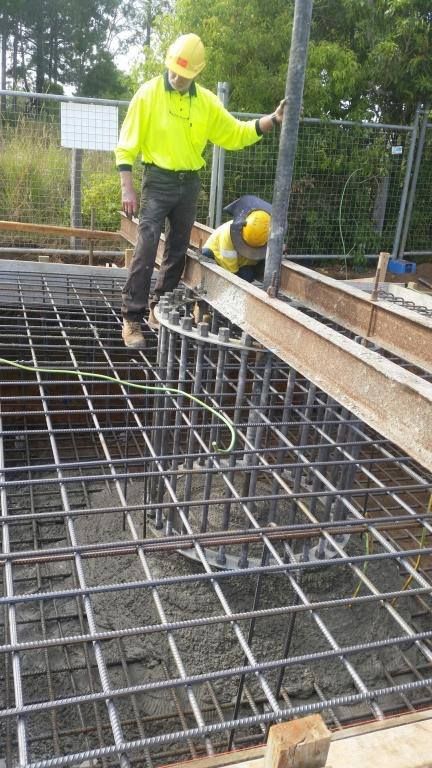 Two Construction Workers Are Working on a Concrete Floor — Tweed Coast Concrete Pumping in Chinderah, NSW