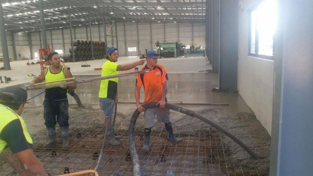 A Group of Construction Workers Are Working on the Floor of a Building — Tweed Coast Concrete Pumping in Chinderah, NSW
