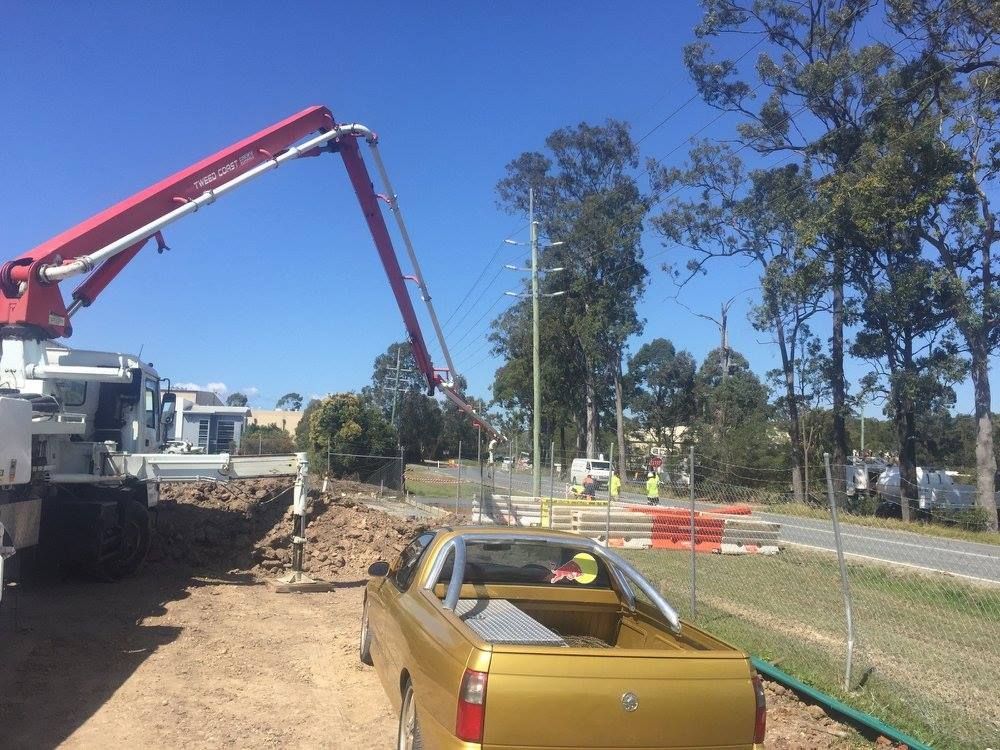 A Yellow Truck is Parked on the Side of the Road Next to a Crane — Tweed Coast Concrete Pumping in Chinderah, NSW
