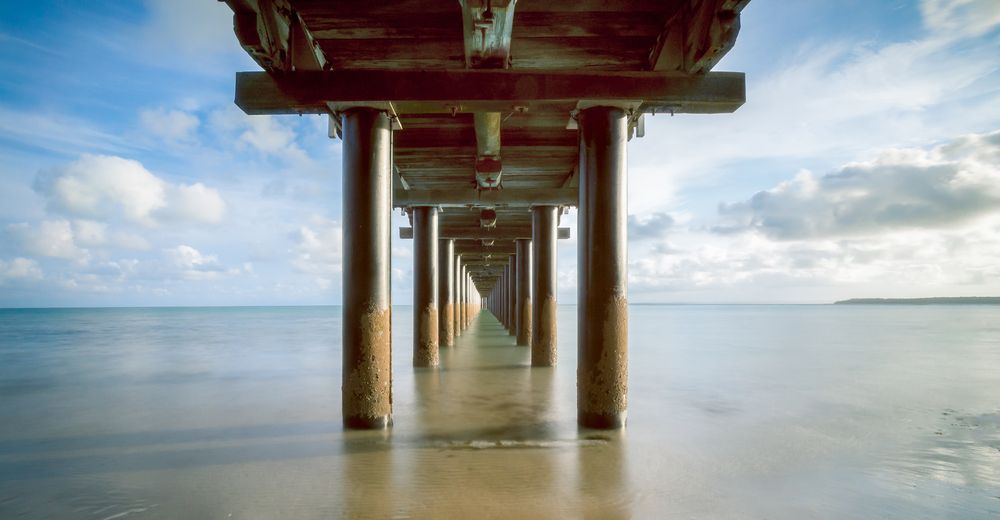 A Pier Going Into the Ocean on a Sunny Day — Tweed Coast Concrete Pumping in Chinderah, NSW
