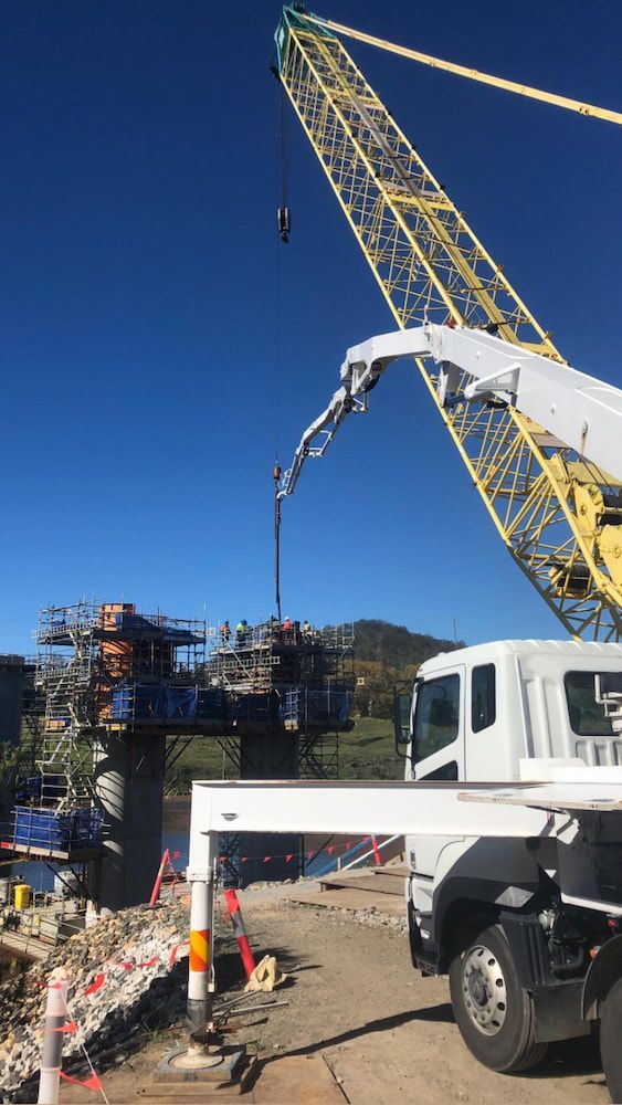 A Truck With a Crane Attached to It is Being Used to Pump Concrete — Tweed Coast Concrete Pumping in Chinderah, NSW