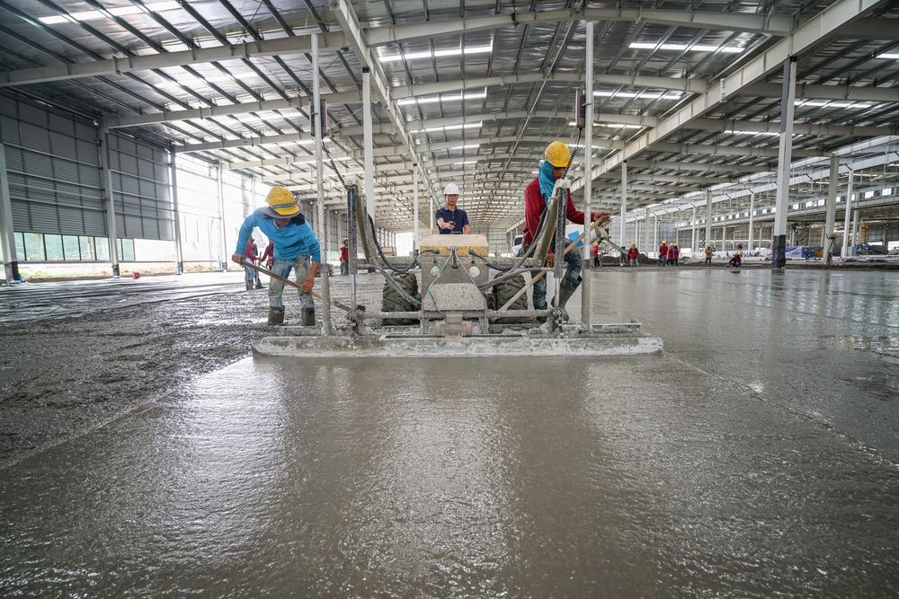 A Group of Construction Workers Are Working on a Concrete Floor — Tweed Coast Concrete Pumping in Coolangatta, QLD