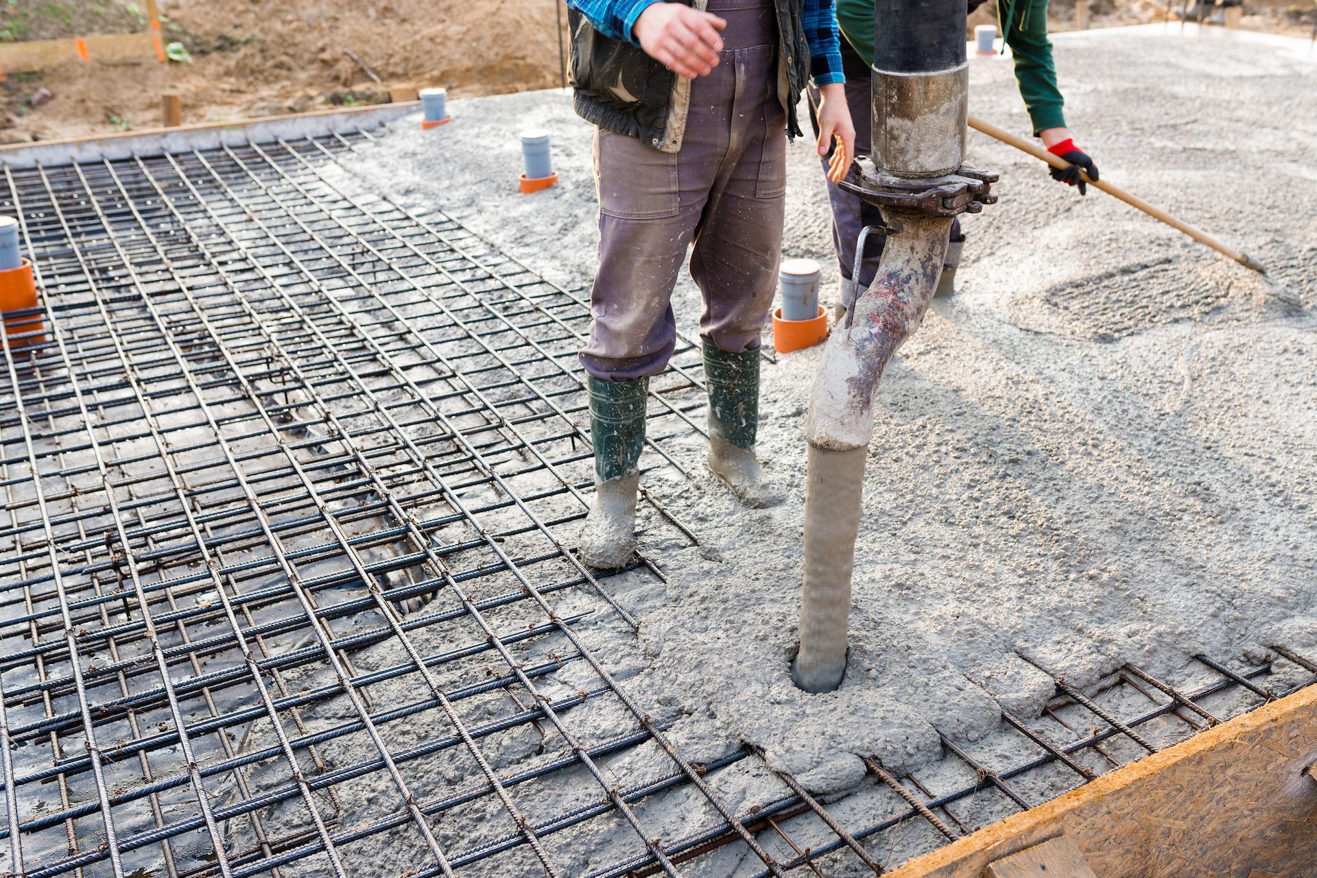 A Man is Pouring Concrete Into a Foundation at a Construction Site — Tweed Coast Concrete Pumping in Tweed Heads, NSW