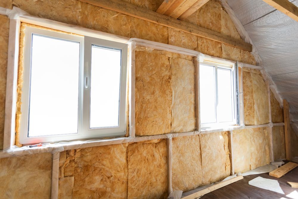 A room with a lot of windows and insulation on the wall.
