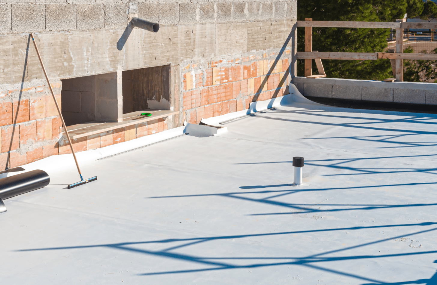 A white roof is being installed on a building under construction.