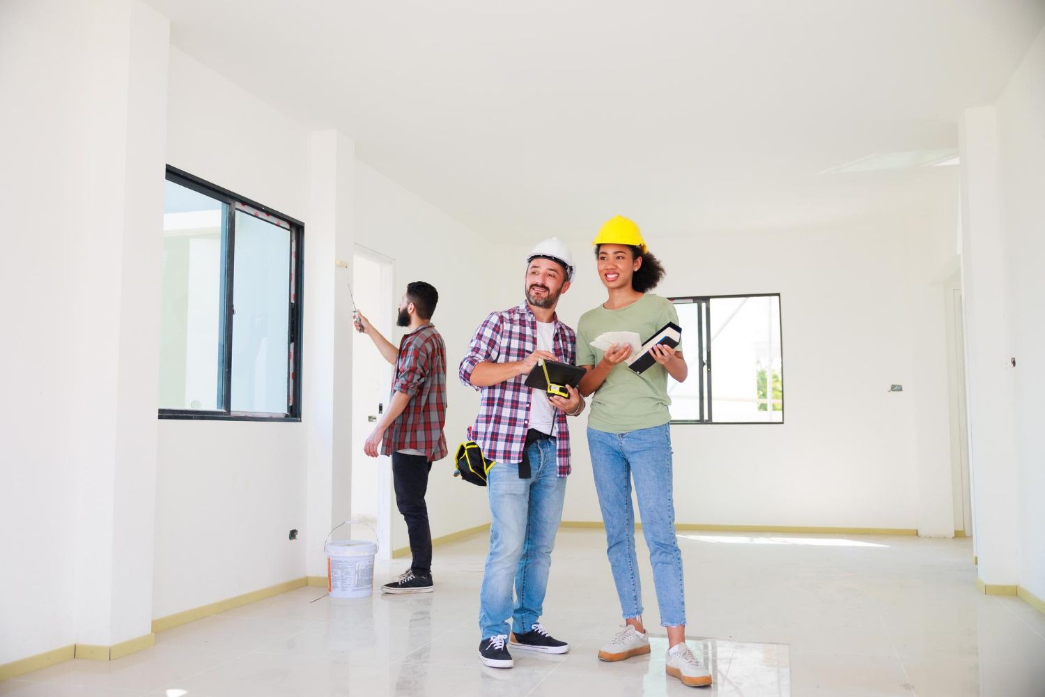 A group of people are standing in an empty room.