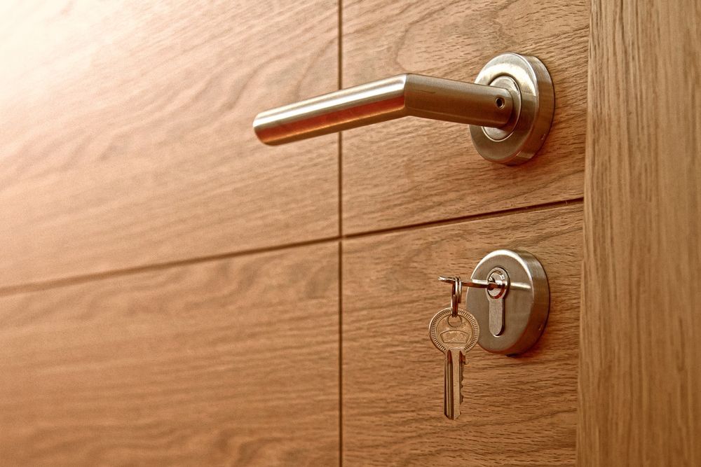 Wooden Door With a Silver Handle and Keys in the Lock — ALUBEST Windows & Doors In Southport, QLD