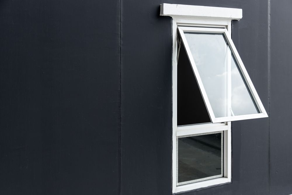 Open White Window on a Dark Exterior Wall — ALUBEST Windows & Doors In Southport, QLD