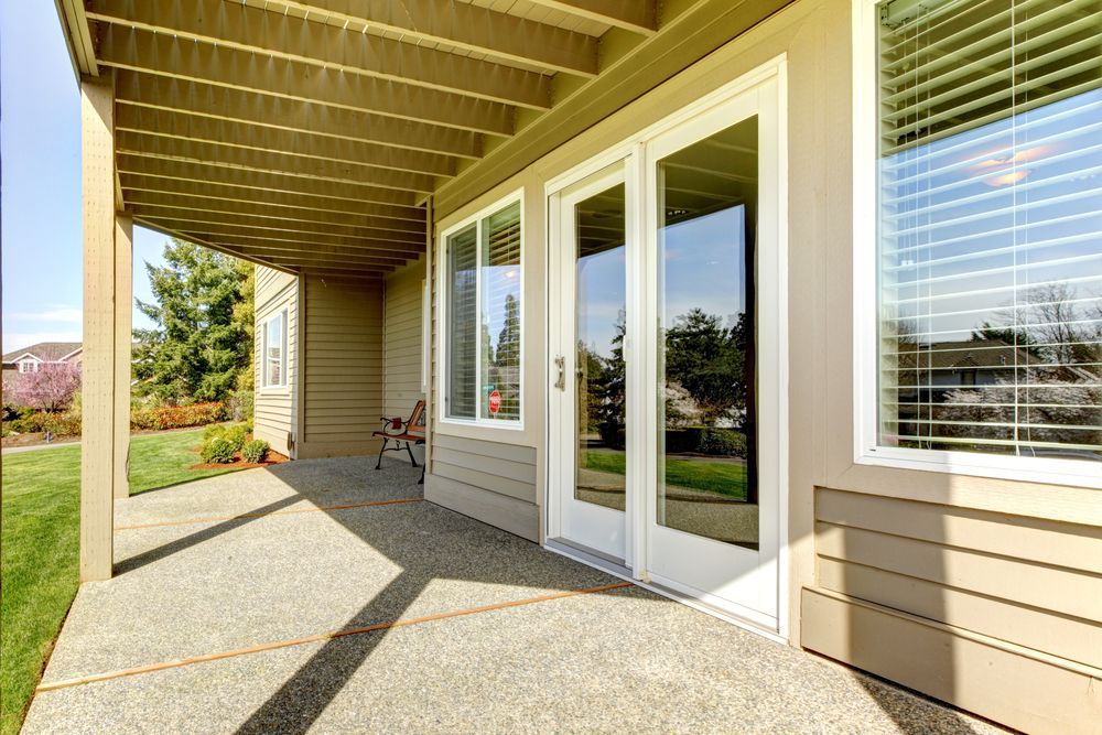 Covered Patio With Beige Siding, Glass Doors, and a Bright Sunlit Concrete Floor — ALUBEST Windows & Doors In Southport, QLD