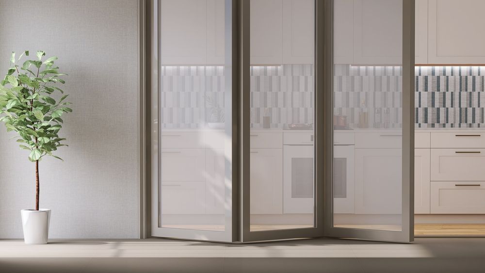 Modern interior bi-fold doors with a potted tree and large frosted glass sliding doors opening to a kitchen — ALUBEST Windows & Doors In Southport, QLD