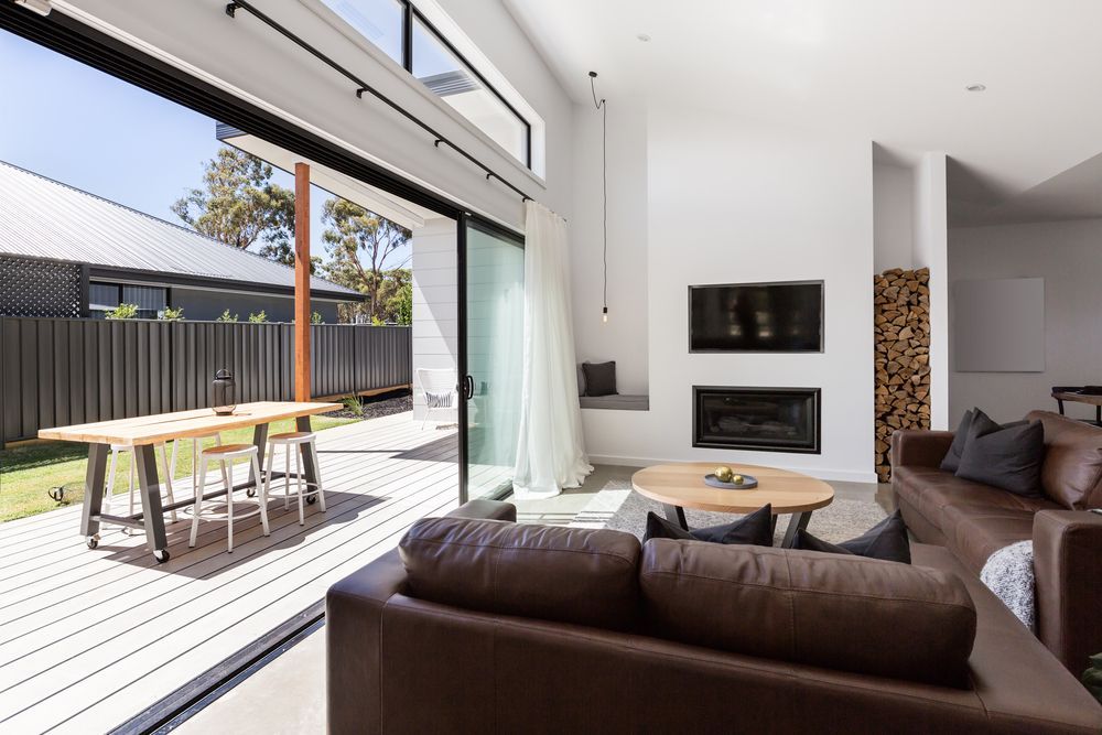 Modern Living Room Opening to Sunny Patio With Dining Table — ALUBEST Windows & Doors In Southport, QLD
